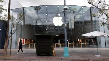 A pedestrian walks past the Apple Store where an employee tested positive for the coronavirus on a deserted Santa Monica Promenade, a popular walking-only shopping street on March 16, 2020 in Santa Monica, California. - Stocks tumbled on March 16, 2020 despite emergency central bank measures to prop up the virus-battered global economy, as countries across Europe started the week in lockdown and major US cities shut bars and restaurants. The virus has upended society around the planet, with governments imposing restrictions rarely seen outside wartime, including the closing of borders, home quarantine orders and the scrapping of public events including major sporting fixtures. (Photo by Frederic J. BROWN / AFP) (Photo by FREDERIC J. BROWN/AFP via Getty Images)