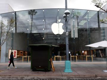 A pedestrian walks past the Apple Store where an employee tested positive for the coronavirus on a deserted Santa Monica Promenade, a popular walking-only shopping street on March 16, 2020 in Santa Monica, California. - Stocks tumbled on March 16, 2020 despite emergency central bank measures to prop up the virus-battered global economy, as countries across Europe started the week in lockdown and major US cities shut bars and restaurants. The virus has upended society around the planet, with governments imposing restrictions rarely seen outside wartime, including the closing of borders, home quarantine orders and the scrapping of public events including major sporting fixtures. (Photo by Frederic J. BROWN / AFP) (Photo by FREDERIC J. BROWN/AFP via Getty Images)