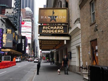 NEW YORK, NEW YORK - JUNE 29: A person walks a dog under the marquee of Hamilton: An American Musical at the Richard Rodgers Theatre on June 29, 2020 in New York City.  Broadway will remain closed until 2021 due to the ongoing coronavirus pandemic. (Photo by Cindy Ord/Getty Images)
