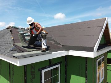 UNIONDALE, NEW YORK - MAY 27:  An aerial view of a construction worker roofing an apartment home on May 27, 2020 in Uniondale, New York.  The residential housing project by Garden City developers Engel Burman will provide approximately 150 construction jobs, help address a dire housing shortage, and support the County by retaining young professionals and senior citizens from fleeing the region.  Today is the first day of Phase 1 of the state’s economic reopening plan on Long Island. Businesses that can partially re-open include construction, manufacturing, and in-store pick-up for retail establishments.  (Photo by Al Bello/Getty Images)
