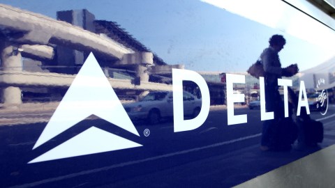 SAN FRANCISCO - OCTOBER 22: A Delta airlines customer is reflected in a sign on a baggage check in kiosk October 22, 2009 at San Francisco International Airport in San Francisco, California. Delta Airlines, the biggest airline in the world, reported a third quarter loss of $161 million, or 19 cents a share compared to a loss of $50 million or 13 cents a share one year ago. (Photo by Justin Sullivan/Getty Images)