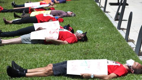 MIAMI BEACH, FLORIDA - MAY 22: Protesters join together in a die-in protest asking the state of Florida to fix its unemployment system on May 22, 2020 in Miami Beach, Florida. Unemployed hospitality and service workers who have not received unemployment checks held the protest demanding Florida Governor Ron DeSantis fix the unemployment system and send out their benefits. Since the closure of all non-essential businesses due to the coronavirus pandemic, hundreds of thousands of hospitality workers across Florida find themselves out of work. Florida’s unemployment system has not worked reliably. (Photo by Joe Raedle/Getty Images)