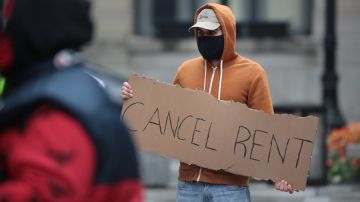 CHICAGO, ILLINOIS  - APRIL 30: A demonstrator calls on the governor to suspend rent and mortgage payments to help those who have lost their income due to the coronavirus during a protest on April 30, 2020 in Chicago, Illinois. On May 1, the state of Illinois will begin requiring everyone to wear a face mask in public when social distancing is not possible to prevent the spread of the coronavirus COVID-19.  The state is currently on a "stay at home" mandated by the governor until May 30. (Photo by Scott Olson/Getty Images)