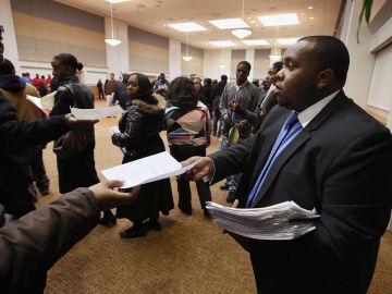 Cory Thames, with the city of Chicago human resources department, collects resumes from Job seekers as they enter a job fair being held at Kennedy-King College and hosted by the city of Chicago on November 9, 2012 in Chicago, Illinois. Thousands of people waited in line beginning at 3AM for the job fair which did not open the doors until 9AM. When the doors opened the line was about a half-mile long.  (Photo by Scott Olson/Getty Images)