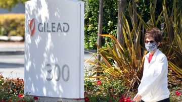 A woman wearing a mask walks by Gilead Sciences headquarters sign in Foster City, California on April 30, 2020. - Gilead Science's remdesivir, one of the most highly anticipated drugs being tested against the new coronavirus, showed positive results in a large-scale US government trial, the company said on April 29, 2020. (Photo by Josh Edelson / AFP) (Photo by JOSH EDELSON/AFP via Getty Images)