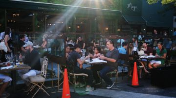 NEW YORK, NEW YORK - JUNE 24: People eat and drink at tables placed outside of a Manhattan restaurant as the city enters Phase 2 of re-opening following restrictions imposed to curb the coronavirus pandemic on June 24, 2020 in New York City. Phase 2 permits the reopening of offices, in-store retail, outdoor dining, barbers and beauty parlors and numerous other businesses. New York state is planning a four-phased gradual reopening in an attempt to stop the spread of the virus. (Photo by Spencer Platt/Getty Images)