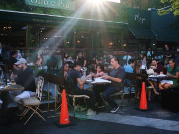 NEW YORK, NEW YORK - JUNE 24: People eat and drink at tables placed outside of a Manhattan restaurant as the city enters Phase 2 of re-opening following restrictions imposed to curb the coronavirus pandemic on June 24, 2020 in New York City. Phase 2 permits the reopening of offices, in-store retail, outdoor dining, barbers and beauty parlors and numerous other businesses. New York state is planning a four-phased gradual reopening in an attempt to stop the spread of the virus. (Photo by Spencer Platt/Getty Images)