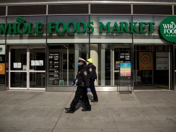 NEW YORK, NEW YORK - APRIL 14: Two New York City Police Department Traffic Enforcement agents walk past the Whole Foods Market on April 14, 2020 in the Brooklyn borough of New York City. (Photo by Justin Heiman/Getty Images)