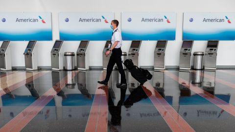 An airline employee walks past empty American Airlines check-in terminals at Ronald Reagan Washington National Airport in Arlington, Virginia, on May 12, 2020. - The airline industry has been hit hard by the COVID-19 pandemic, with the number of people flying having decreased by more than 90 percent since the beginning of March. (Photo by ANDREW CABALLERO-REYNOLDS / AFP) (Photo by ANDREW CABALLERO-REYNOLDS/AFP via Getty Images)