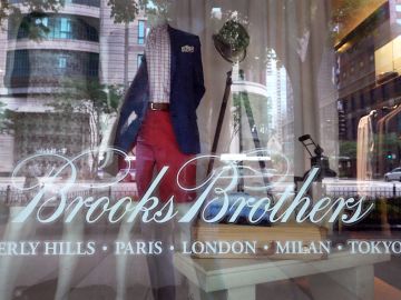 CHICAGO, ILLINOIS - JULY 08: The Brooks Brothers logo is painted on the window of a closed store along the Magnificent Mile on July 08, 2020 in Chicago, Illinois. The retailer which was founded in 1818 and currently has more than 500 stores worldwide filed for bankruptcy protection today.  (Photo by Scott Olson/Getty Images)