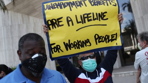 MIAMI SPRINGS, FLORIDA - JULY 16: Carlos Ponce joins other demonstrators participating in a protest asking Senators to support the continuation of unemployment benefits on July 16, 2020 in Miami Springs, Florida. The protesters were asking Senators to support the new Schumer/Wyden legislation that extends unemployment benefits for all laid-off Americans as the coronavirus pandemic continues to disrupt the economy. (Photo by Joe Raedle/Getty Images)