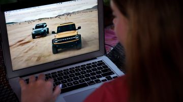 This illustration picture shows a person watching the 2021 Ford Bronco Family World Premiere on a computer in Arlington, Virginia on July 13, 2020. - US automaker Ford unveiled new versions of its legendary Bronco 4x4 on July 13, hoping to attract a new generation of enthusiasts 24 years after it stopped production and enter into direct competition with Fiat Chrysler's Jeep. (Photo by Olivier DOULIERY / AFP) (Photo by OLIVIER DOULIERY/AFP via Getty Images)