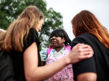 Women pray during a ceremony for the 155th anniversary of Juneteenth near the site where George Floyd died in police custody in Minneapolis, Minnesota, on June 19, 2020. - The US marks the end of slavery by celebrating Juneteenth, with the annual unofficial holiday taking on renewed significance as millions of Americans confront the nation's living legacy of racial injustice. (Photo by Kerem Yucel / AFP) (Photo by KEREM YUCEL/AFP via Getty Images)