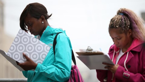 SAN FRANCISCO, CA - AUGUST 15: Job seekers fill out applications as they wait in line to enter a job fair at a new Target retail store on August 15, 2013 in San Francisco, California. Hundreds of job seekers applied for jobs during a job fair to staff a new Target City store. According to a report by the Labor Department, the number of people seeking first time unemployment benefits fell to the lowest level since 2007 with initial jobless claims decreasing by 15,000 to 320,000. (Photo by Justin Sullivan/Getty Images)