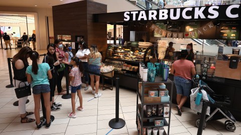 GLENDALE, ARIZONA - JUNE 20:  Consumers wait in line at a  Starbucks location as they return to retail shopping at the Arrowhead Towne Center on June 20, 2020 in Glendale, Arizona. Arizona is one of the 19 states with the trend of new coronavirus (COVID-19) cases still increasing. Gov. Doug Ducey allowed individual Arizona cities to create their own policies about face-covering requirements and enforcement on Wednesday. (Photo by Christian Petersen/Getty Images)