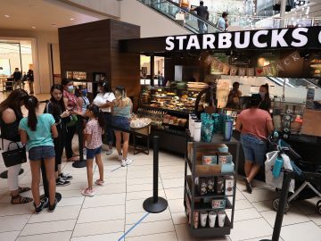 GLENDALE, ARIZONA - JUNE 20:  Consumers wait in line at a  Starbucks location as they return to retail shopping at the Arrowhead Towne Center on June 20, 2020 in Glendale, Arizona. Arizona is one of the 19 states with the trend of new coronavirus (COVID-19) cases still increasing. Gov. Doug Ducey allowed individual Arizona cities to create their own policies about face-covering requirements and enforcement on Wednesday. (Photo by Christian Petersen/Getty Images)