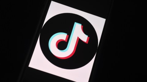 In this photo illustration, the social media application logo, TikTok is displayed on the screen of an iPhone on April 13, 2020, in Arlington, Virginia - TikTok has pledged $250 million to local organizations around the world supporting healthcare, education, and struggling communities impacted by the coronavirus pandemic. (Photo by Olivier DOULIERY / AFP) (Photo by OLIVIER DOULIERY/AFP via Getty Images)