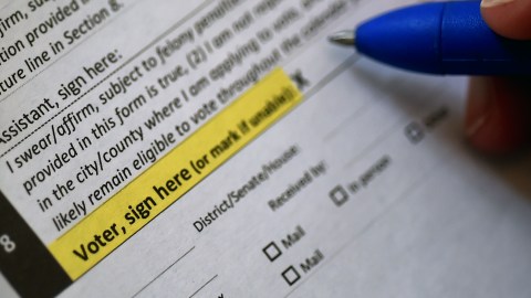 This illustration photo shows a Virginia resident filling out an application to vote by mail ahead of the November Presidential election, on August 6, 2020 in Arlington, Virginia. (Photo by Olivier DOULIERY / AFP) (Photo by OLIVIER DOULIERY/AFP via Getty Images)