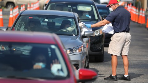 HIALEAH, FLORIDA - APRIL 08: Miguel Diaz, who works for the City of Hialeah, hands out unemployment applications to people in their vehicles in front of the John F. Kennedy Library on April 08, 2020 in Hialeah, Florida. The city is distributing the printed unemployment forms to residents as people continue to have issues with access to the state of Florida’s unemployment website in the midst of widespread layoffs due to businesses closing during the coronavirus pandemic. (Photo by Joe Raedle/Getty Images)