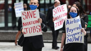 Airline industry workers hold signs during a protest in Federal Plaza in Chicago, Illinois, on September 9, 2020. - Other protests where held in Washington, DC outside the US Capitol, organized by the Association of Flight Attendants urging the US Congress to pass a Covid-19 relief package and extend the Paycheck Support Program to save aviation jobs. (Photo by KAMIL KRZACZYNSKI / AFP) (Photo by KAMIL KRZACZYNSKI/AFP via Getty Images)