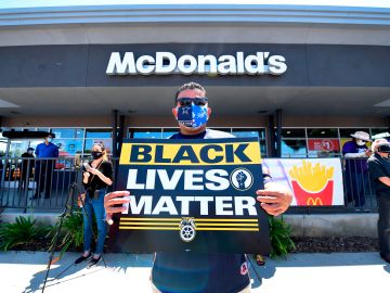 Activists protest in front of a McDonalds in Los Angeles, California, on July 20, 2020 during a Strike For Black Lives rally. - The Strike For Black Lives rally, which brought together labour unions, fast food restaurant workers and racial and social justice groups and a car caravan in support of Black Lives Matter, is taking place in numerous cities across America. Tens of thousands of union workers joined social and racial justice advocates in more than 25 US cities in walking off the job July 20, 2020, in support of dismantling systemic racism. (Photo by Frederic J. BROWN / AFP) (Photo by FREDERIC J. BROWN/AFP via Getty Images)