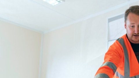 Mujer trabaja con un hombre en unos planos.