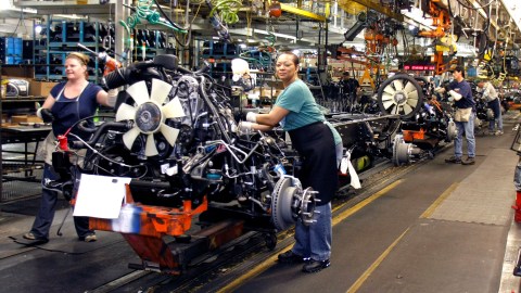 FLINT, MI - JANUARY 24: Two women work on the engine of a GM truck on the assembly line of the General Motors Flint Assembly Plant January 24, 2011 in Flint, Michigan. In response to customer demand GM announced they are adding a third shift and an estimated 750 jobs at the plant. (Photo by Bill Pugliano/Getty Images)