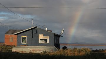 KIVALINA, ALASKA - SEPTEMBER 10:  A rainbow is seen behind a home on September 10, 2019 in Kivalina, Alaska. Kivalina is situated at the very end of an eight-mile barrier reef located between a lagoon and the Chukchi Sea. The village is 83 miles above the Arctic circle. Kivalina and a few other native coastal Alaskan villages face the warming of the Arctic, which has resulted in the loss of sea ice that buffers the island’s shorelines from storm surges and coastal erosion. The residents of Kivalina are hoping to stay on their ancestral lands where they can preserve their culture, rather than dispersing due to their island being swallowed by the rising waters of the ocean.  City Administrator Colleen Swan says that the way of life in the village will change with the changing climate and they will adapt. In days gone by, they could migrate with the changes. But now, she says, with the magnitude of problem climate change brings, they must hope that the rest of the world reverses the trend, which she sees as being man-made, and save their way of life.   on September 10, 2019 in Kivalina, Alaska.  (Photo by Joe Raedle/Getty Images)