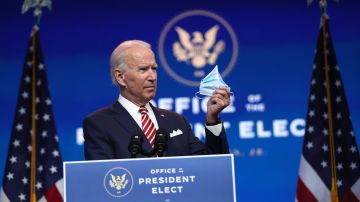 WILMINGTON, DELAWARE - NOVEMBER 16:  U.S. President-elect Joe Biden holds up a face mask as he delivers remarks about the U.S. economy during a press briefing at the Queen Theater on November 16, 2020 in Wilmington, Delaware. He repeated his belief that wearing a mask should not be a political statement. Mr. Biden and his advisors continue to work on the long term economic recovery plan his administration will try to put in place when he takes office. (Photo by Joe Raedle/Getty Images)