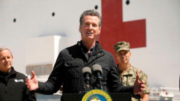 California Governor Gavin Newsom (C), flanked by Director Mark Ghilarducci, Cal OES, (L) and Admiral John Gumbleton, United States Navy, speaks in front of the hospital ship USNS Mercy after it arrived into the Port of Los Angeles on March 27, 2020. - The USNS Mercy, a giant US naval hospital ship, arrived in Los Angeles on March 27, where it will be used to ease the strain on the city's coronavirus-swamped emergency rooms. (Photo by Carolyn Cole / POOL / AFP) (Photo by CAROLYN COLE/POOL/AFP via Getty Images)