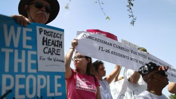 MIAMI, FL - AUGUST 03:  Laura Hernandez (2nd L) and Andrea Pimentel join others for a protest in front of the office of Rep. Carlos Curbelo (R-FL) on August 3, 2017 in Miami, Florida. The protesters are asking for Rep. Curbelo to explain his vote on the Affordable Care Act and to take a stand against what they say is 'President Donald Trump's budget that slashes Medicaid by more than $800 billion and weakens the social safety net for more than 113,000 residents in Rep. Curbelo's district who rely on Medicaid. '(Photo by Joe Raedle/Getty Images)