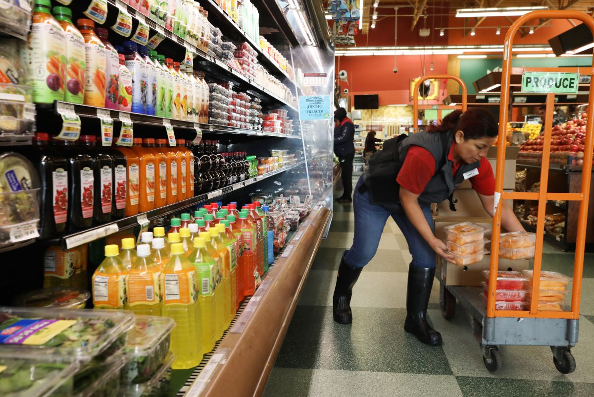 Una trabajadora latina acomoda artículos en un supermercado de Los Ángeles, California.