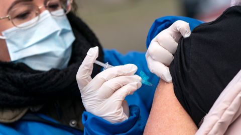 A nurse wearing a face mask injects the vaccine against influenza to a high-risk patient, outdoors to prevent the spread of the coronavirus Covid-19, in Trelleborg, southern Sweden, on November 19, 2020. (Photo by Johan NILSSON / TT NEWS AGENCY / AFP) / Sweden OUT (Photo by JOHAN NILSSON/TT NEWS AGENCY/AFP via Getty Images)