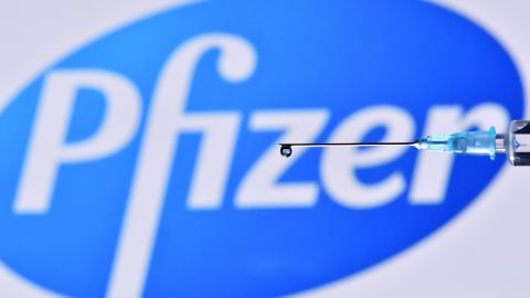 An illustration picture shows a drop from a syringe with the logo of US pharmaceutical company Pfizer on November 17, 2020. (Photo by JUSTIN TALLIS / AFP) (Photo by JUSTIN TALLIS/AFP via Getty Images)