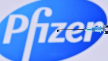 An illustration picture shows a drop from a syringe with the logo of US pharmaceutical company Pfizer on November 17, 2020. (Photo by JUSTIN TALLIS / AFP) (Photo by JUSTIN TALLIS/AFP via Getty Images)