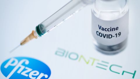 This illustration picture taken on November 23, 2020 shows a bottle reading "Vaccine Covid-19" and a syringe next to the Pfizer and Biontech logo. - The European Commission has signed five contracts to pre-order vaccines, among which with the U.S.-German company Pfizer-BioNTech (up to 300 million doses). (Photo by JOEL SAGET / AFP) (Photo by JOEL SAGET/AFP via Getty Images)