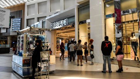Customers stand in line outside "Forever 21" store inside a Mall west of Fort Lauderdale, Florida on May 18, 2020. - South Florida begins a gradual reopening of its economy on May 18,2020 with the start of activities of some restaurants and businesses in Miami and Fort Lauderdale, but the beaches will still be closed until further notice.The opening "phase 1" in this region also does not include hotels, bars, nightclubs, gyms, movie theatres or massage parlours. (Photo by CHANDAN KHANNA / AFP) (Photo by CHANDAN KHANNA/AFP via Getty Images)