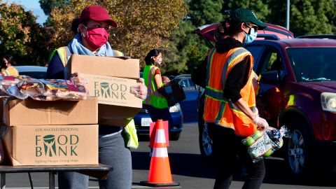 Food is loaded as drivers in their vehicles wait in line on arrival at a "Let's Feed LA County" food distribution hosted by the Los Angeles Food Bank on December 4, 2020 in Hacienda Heights, California. - While coronavirus cases continue to surge nationwide and shutdowns return, the US economic recovery stalls with just 245,000 jobs in the final report of 2020 as the unemployment rate fell to 6.7 percent, according to Bureau of Labour Statistics. (Photo by Frederic J. BROWN / AFP) (Photo by FREDERIC J. BROWN/AFP via Getty Images)