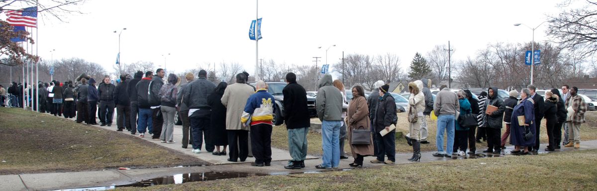 Decenas de personas hacen fila para ingresar a una feria de empleo en Detroit, Michigan.