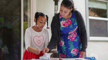 Adrienne Williams does school work with her daughter Gia, 7, at her mother's house in Pinole, California, on May 13, 2020. - She delivers for Amazon, but Adrienne Williams says the e-commerce and tech giant did not deliver for her. The 42-year-old California single mother is among the legion of drivers for Amazon's third-party delivery firms which have been struggling amid surging demand for goods and supplies to locked-down consumers during the pandemic. (Photo by Virginie GOUBIER / AFP) (Photo by VIRGINIE GOUBIER/AFP via Getty Images)