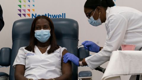 Sandra Lindsay(L), a nurse at Long Island Jewish Medical Center, is inoculated with the Covid-19 vaccine by Dr. Michelle Chester, at Long Island Jewish Medical Center, on December 14, 2020 in the Queens borough of New York. - The rollout of the Pfizer and BioNTech vaccine, the first to be approved by the Food and Drug Administration, ushers in the biggest vaccination effort in US history. More than 299,000 Americans have been killed by the virus, including over 35,000 residents of New York state. (Photo by Mark Lennihan / POOL / AFP) (Photo by MARK LENNIHAN/POOL/AFP via Getty Images)