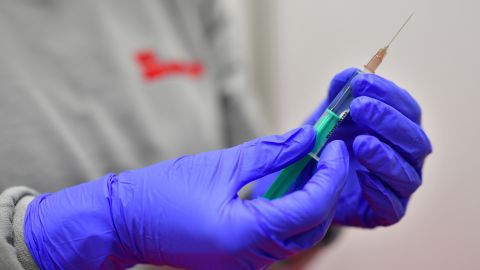 OSNABRUECK, GERMANY - DECEMBER 13: A medical worker of the Johanniter, a Protestant aid organization, holds a syringe filled with saline solution during a test run at a future Covid-19 vaccine center on December 13, 2020 in Osnabrueck, Germany. Across Germany event arenas, trade fair halls, gymnasiums and other venues are being converted into vaccine centers, with many beginning test runs ahead of approval by European Union health authorities of the new vaccine. The first real inoculations could begin by the end of December. (Photo by Alexander Koerner/Getty Images)