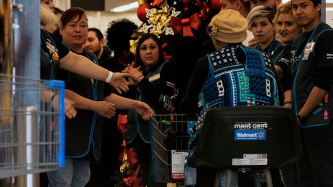 Employees gather as Walmart Supercenter on Gateway West in El Paso,Texas was reopened after an American flag atop the store was raised from half mast and a banner displaying "El Paso Strong" was unveiled on November 14, 2019. - Walmart executives gathered in El Paso, Texas on November 14, 2019 to reopen the store that was the scene of a gruesome massacre three months ago that killed 22 people. Newly-installed Walmart US President and CEO John Furner said the company listened to its employees and local residents to decide on the timing of the move to open the doors to the public.A 21-year-old is accused in the shooting rampage at the store on August 3 in response to what he called a "Hispanic invasion" of Texas, killing 22 people dead and wounding many more. (Photo by Paul Ratje / AFP) (Photo by PAUL RATJE/AFP via Getty Images)