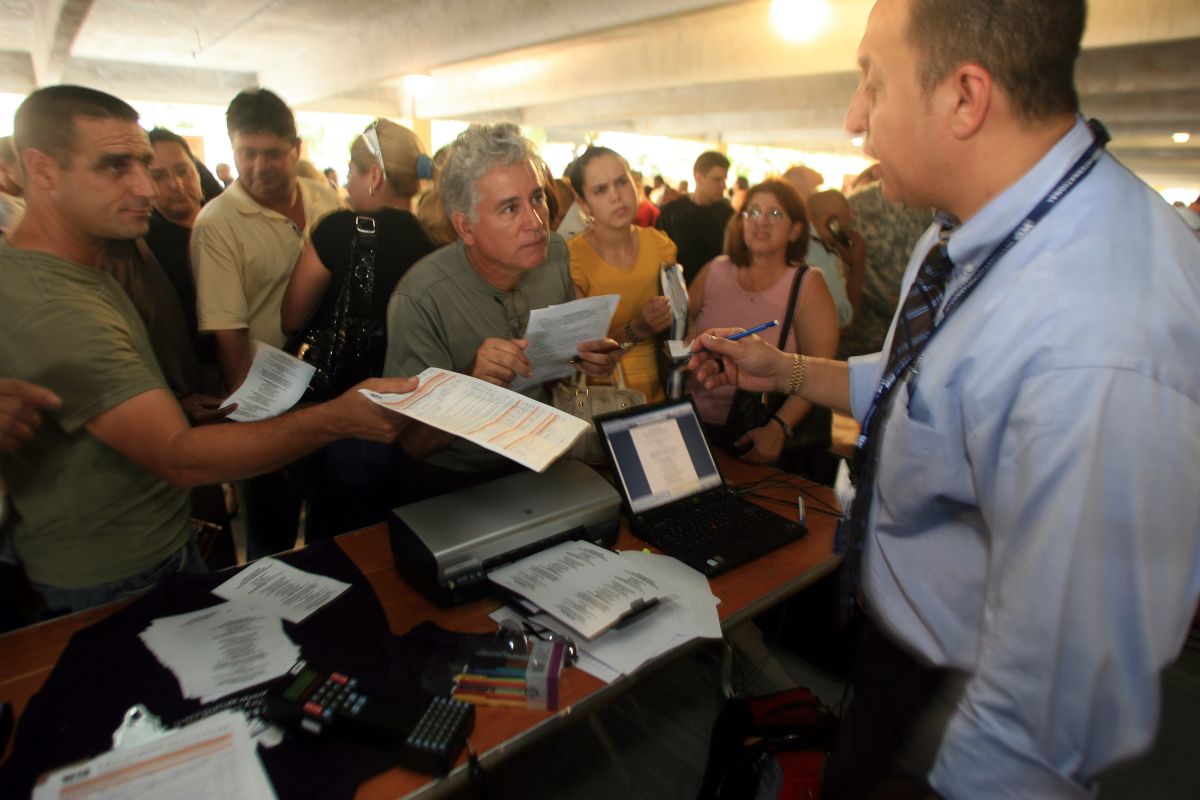 Desempleados presentan solicitudes en una feria de trabajo en Miami, Florida.