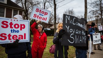 LOUISVILLE, KY - JANUARY 02: DC Under Siege protesters display their Stop The Steal signs in front Sen. Majority Leader Mitch McConnell's vandalized home on January 2, 2021 in Louisville, Kentucky. Black Lives Matter demonstrators and right-wing DC Under Siege members gathered during the Won't Back Down Rally to protest Sen. McConnell's decision to block the most recent stimulus bill. (Photo by Jon Cherry/Getty Images)