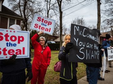 LOUISVILLE, KY - JANUARY 02: DC Under Siege protesters display their Stop The Steal signs in front Sen. Majority Leader Mitch McConnell's vandalized home on January 2, 2021 in Louisville, Kentucky. Black Lives Matter demonstrators and right-wing DC Under Siege members gathered during the Won't Back Down Rally to protest Sen. McConnell's decision to block the most recent stimulus bill. (Photo by Jon Cherry/Getty Images)