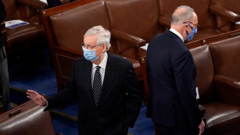 WASHINGTON, DC - JANUARY 06: Senate Majority Leader Mitch McConnell (L) (R-KY) and Senate Minority Leader Chuck Schumer (R) (D-NY) stand back to back in the House Chamber during a joint session of Congress on January 06, 2021 in Washington, DC. Congress held a joint session today to ratify President-elect Joe Biden's 306-232 Electoral College win over President Donald Trump. A group of Republican senators said they would reject the Electoral College votes of several states unless Congress appointed a commission to audit the election results. (Photo by Drew Angerer/Getty Images)