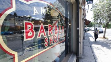 LOS ANGELES, CALIFORNIA - JULY 14: A pedestrian walks past a barbershop which is closing amid new closures and restrictions due to the COVID-19 pandemic on July 14, 2020 in Los Angeles, California. California Governor Gavin Newsom announced updated restrictions including a statewide closure of bars, indoor dining, zoos, malls and museums following a surge in the spread of the coronavirus. In addition, most counties including Los Angeles county must shutter worship services, gyms, hair salons, barbershops and some other businesses. (Photo by Mario Tama/Getty Images)