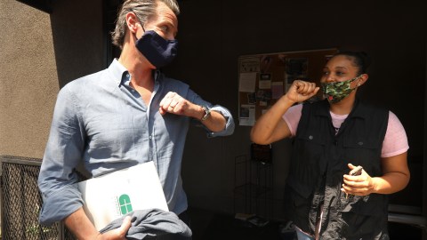 California Governor Gavin Newsom bumps elbows with Candace O'Connor, owner of Brimberry Barber and Beauty Salon, after she shared her thoughts on running a business in the time of COVID-19 and the recent protests in Los Angeles on June 3, 2020. (Photo by Genaro Molina / POOL / AFP) (Photo by GENARO MOLINA/POOL/AFP via Getty Images)