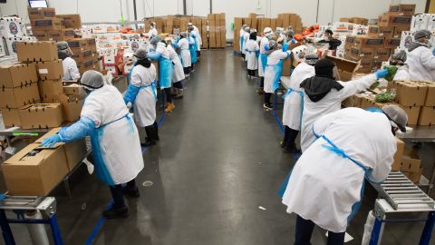 Workers  assemble boxes of food as part of the Farmers to Families Food Box Program at Coastal Sunbelt Produce in Laurel, Maryland, May 15, 2020. - Through the program, US Department of Agriculture purchases and distributes up to $3 billion in fresh produce, dairy and meat products for food boxes that will be delivered to food banks, community and faith-based organizations and other non-profits serving Americans in need. (Photo by SAUL LOEB / AFP) (Photo by SAUL LOEB/AFP via Getty Images)